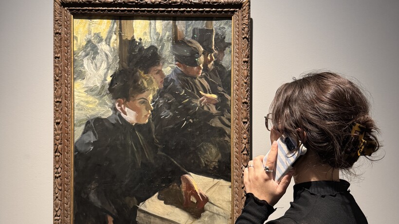 Audiotour Zorn_Hamburger kunsthalle, eine weibliche Besucherin steht mit einem Smartphone am Ohr vor einem Anders Zorn Werk.